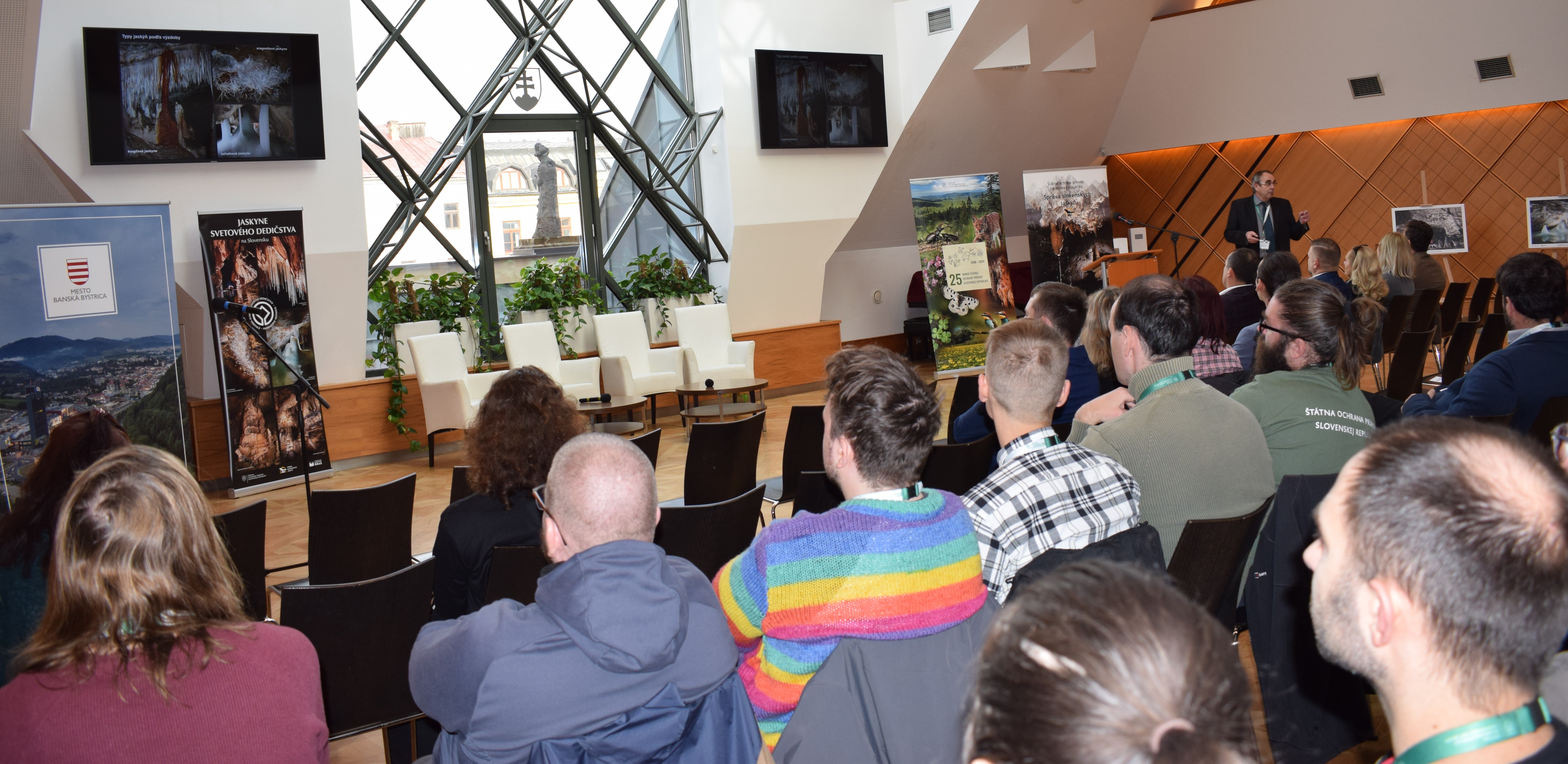 doc. RNDr. Bella Pavel, PhD. prezentuje jaskynné systémy a typy výzdoby na plátne pred účastníkmi konferencie.